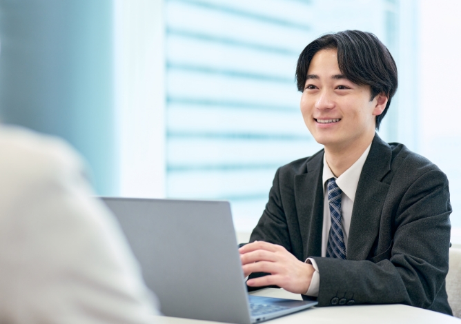 PCの前で微笑む社員