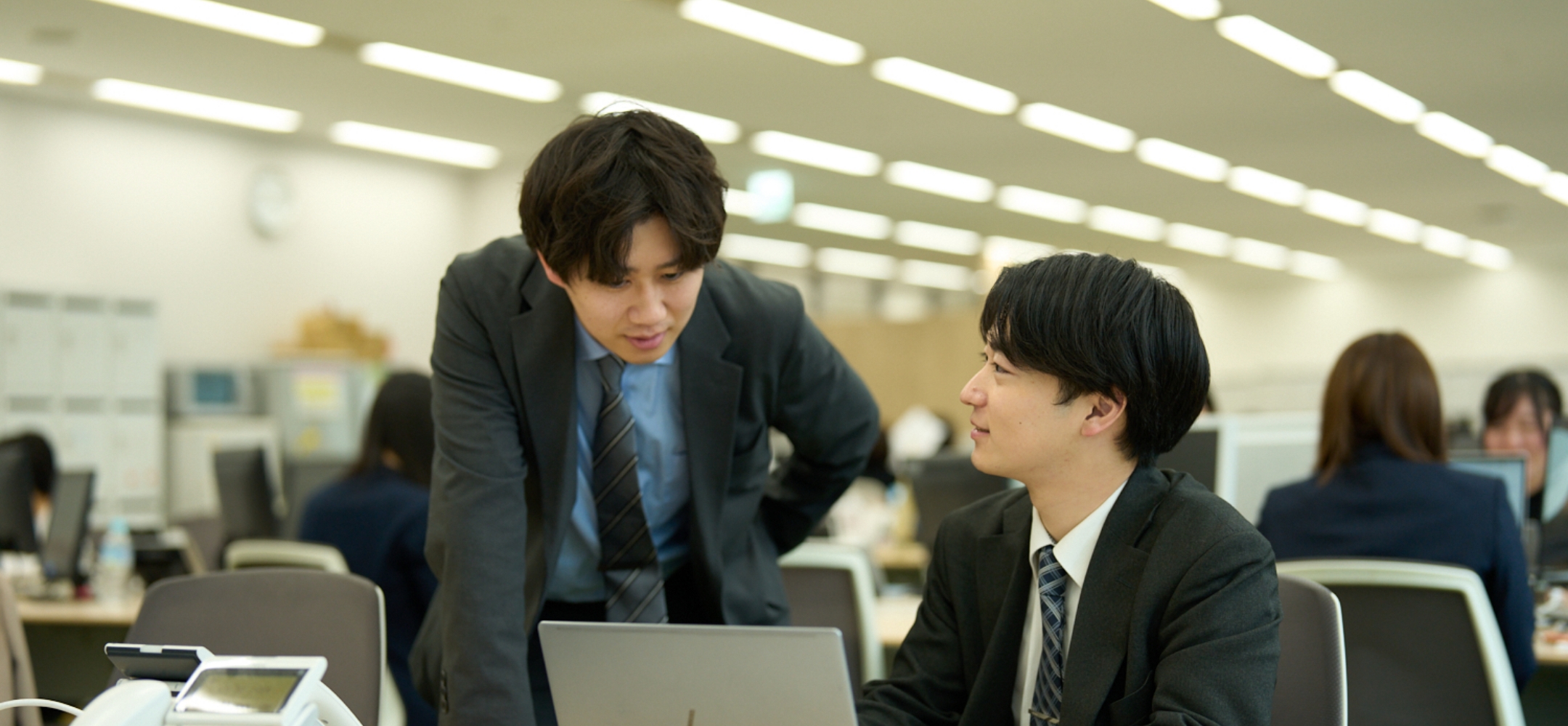 PCの前で相談する男性写真